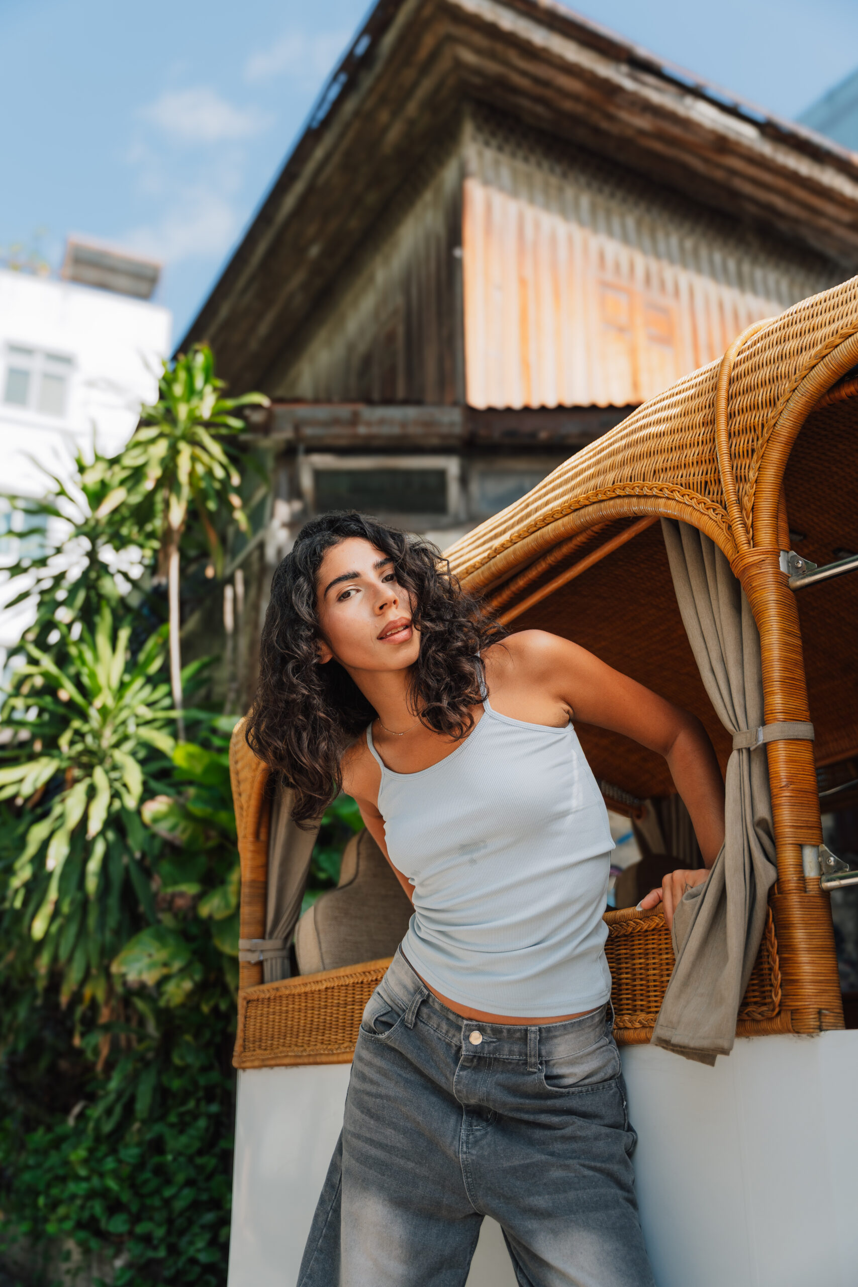 Detail shot of model framed by the woven TukMe tuk-tuk in Bangkok by Cameron McDonald